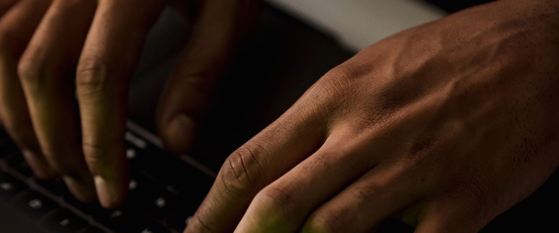 Hands typing on a laptop keyboard